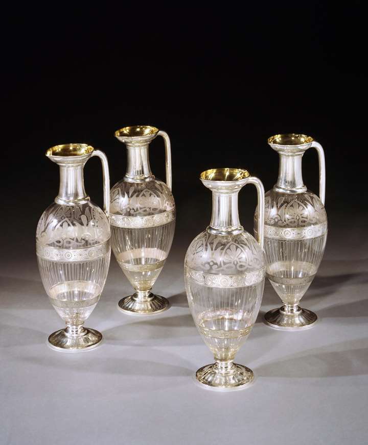 A set of four silver mounted etched glass claret jugs